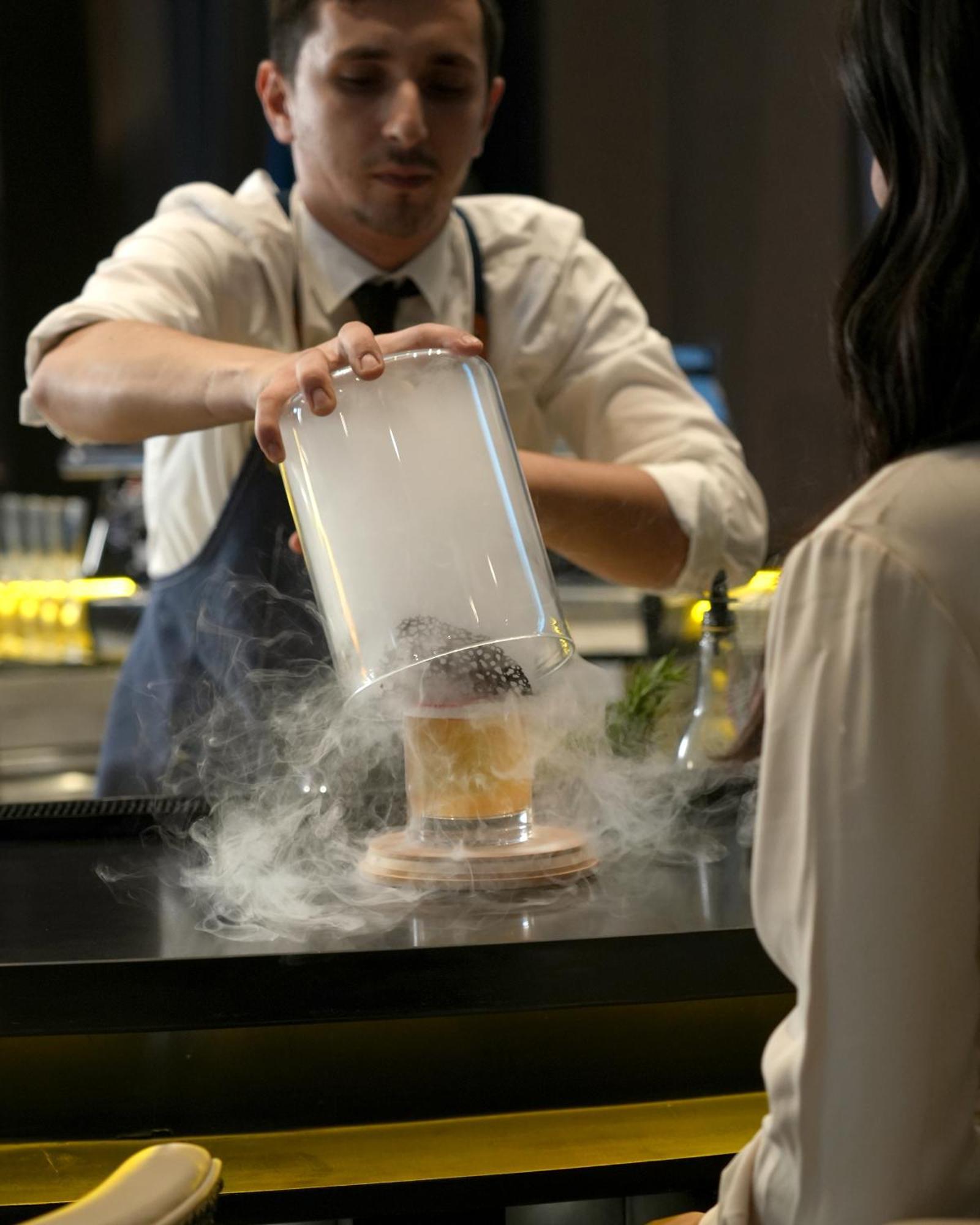 Fairmont Riaad Buitenkant foto A bartender preparing a cocktail with liquid nitrogen