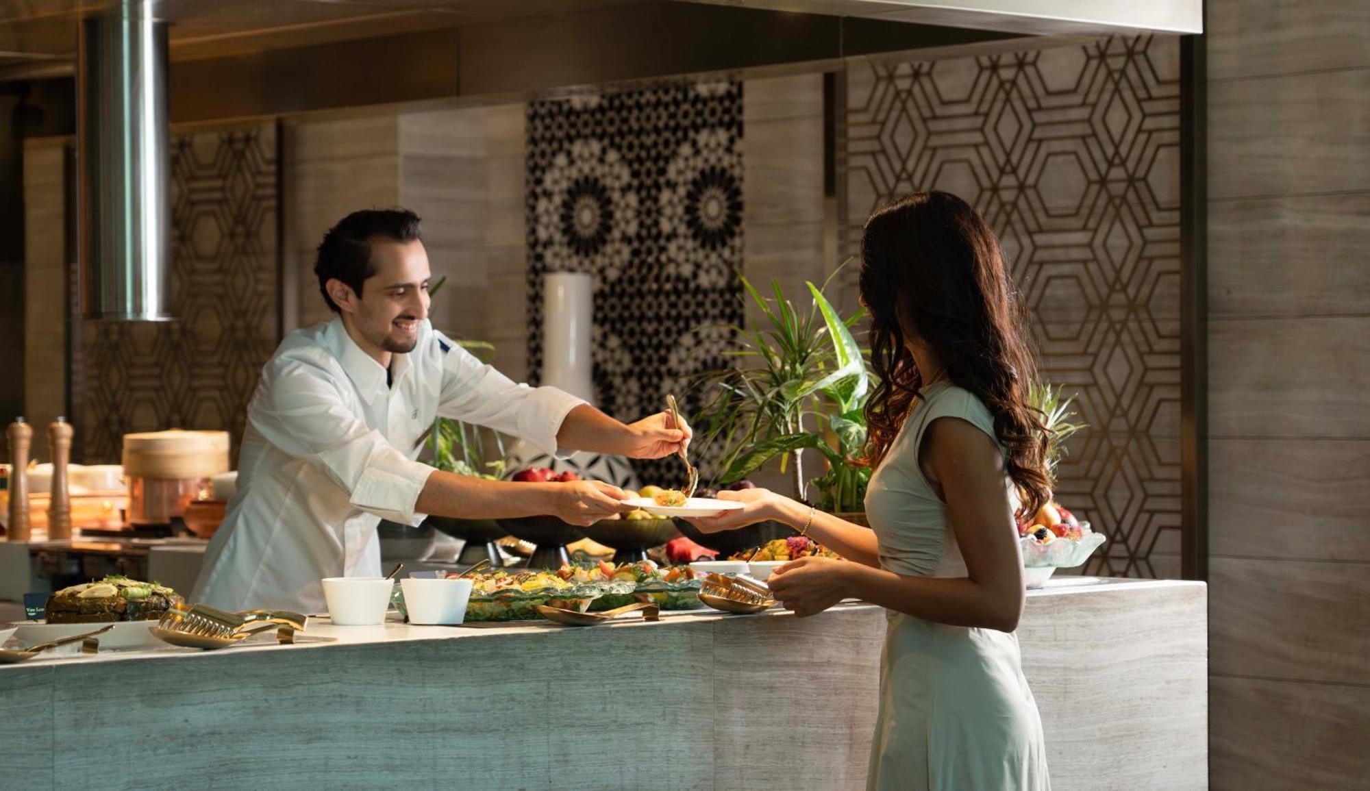 Fairmont Riaad Buitenkant foto A chef serving a guest at the buffet