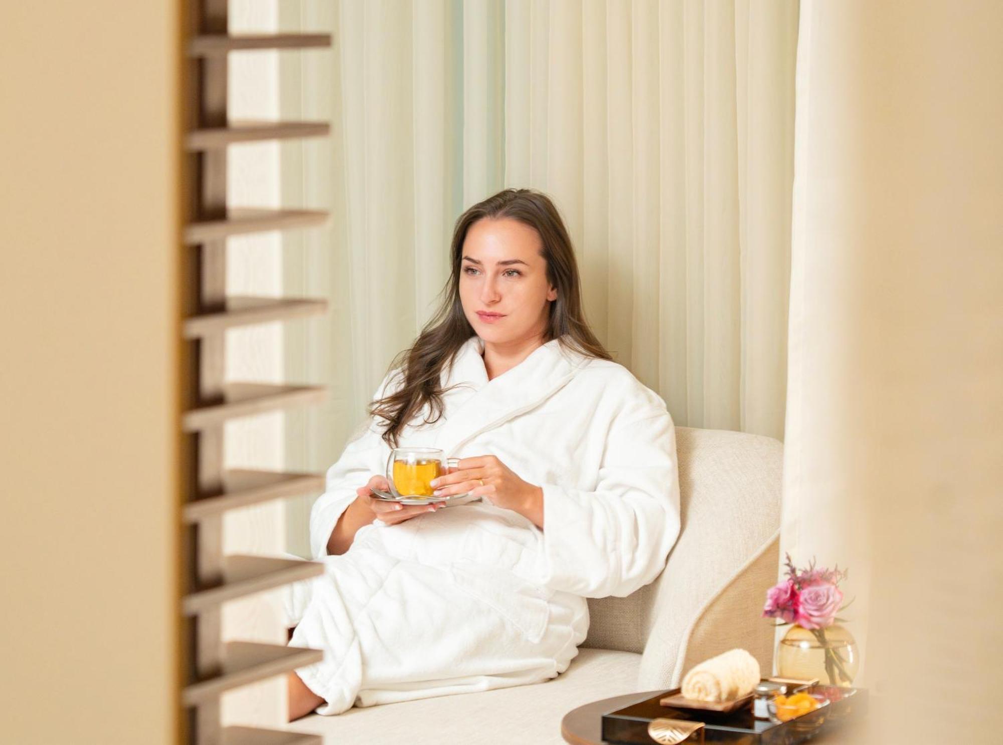 Fairmont Riaad Buitenkant foto A woman wearing a bathrobe